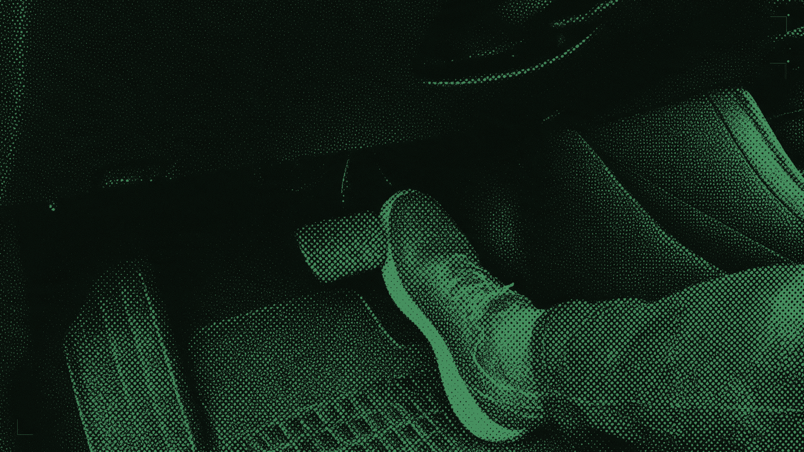A shoe resting just beside a second brake pedal in the passenger footwell of a driving-school car