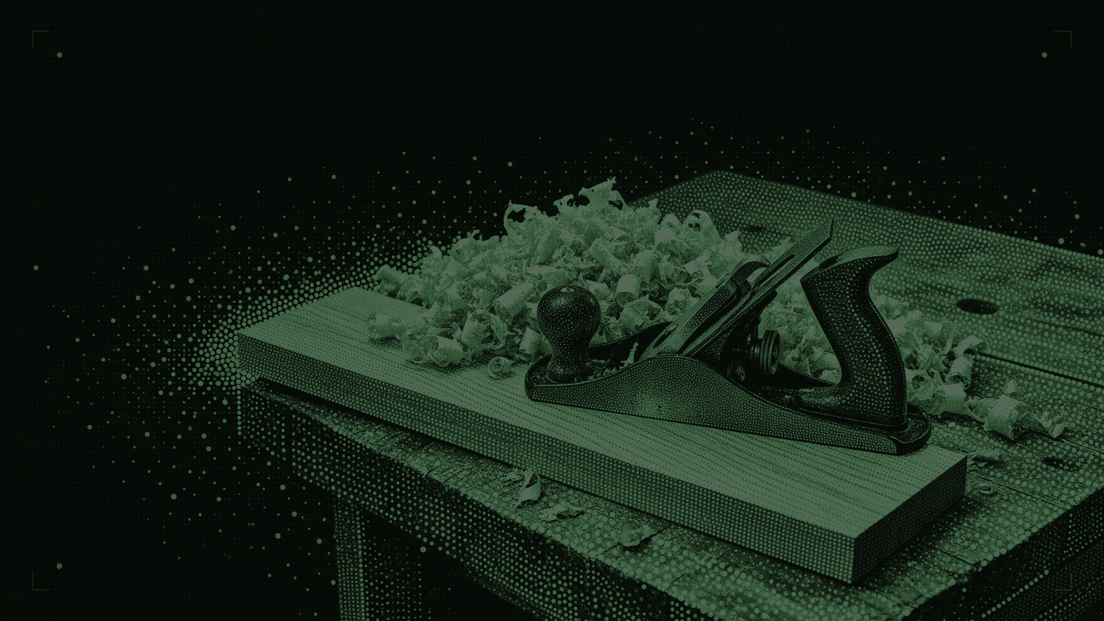A hand plane resting on a long board, with a deep pile of curled wood shavings behind it on the bench