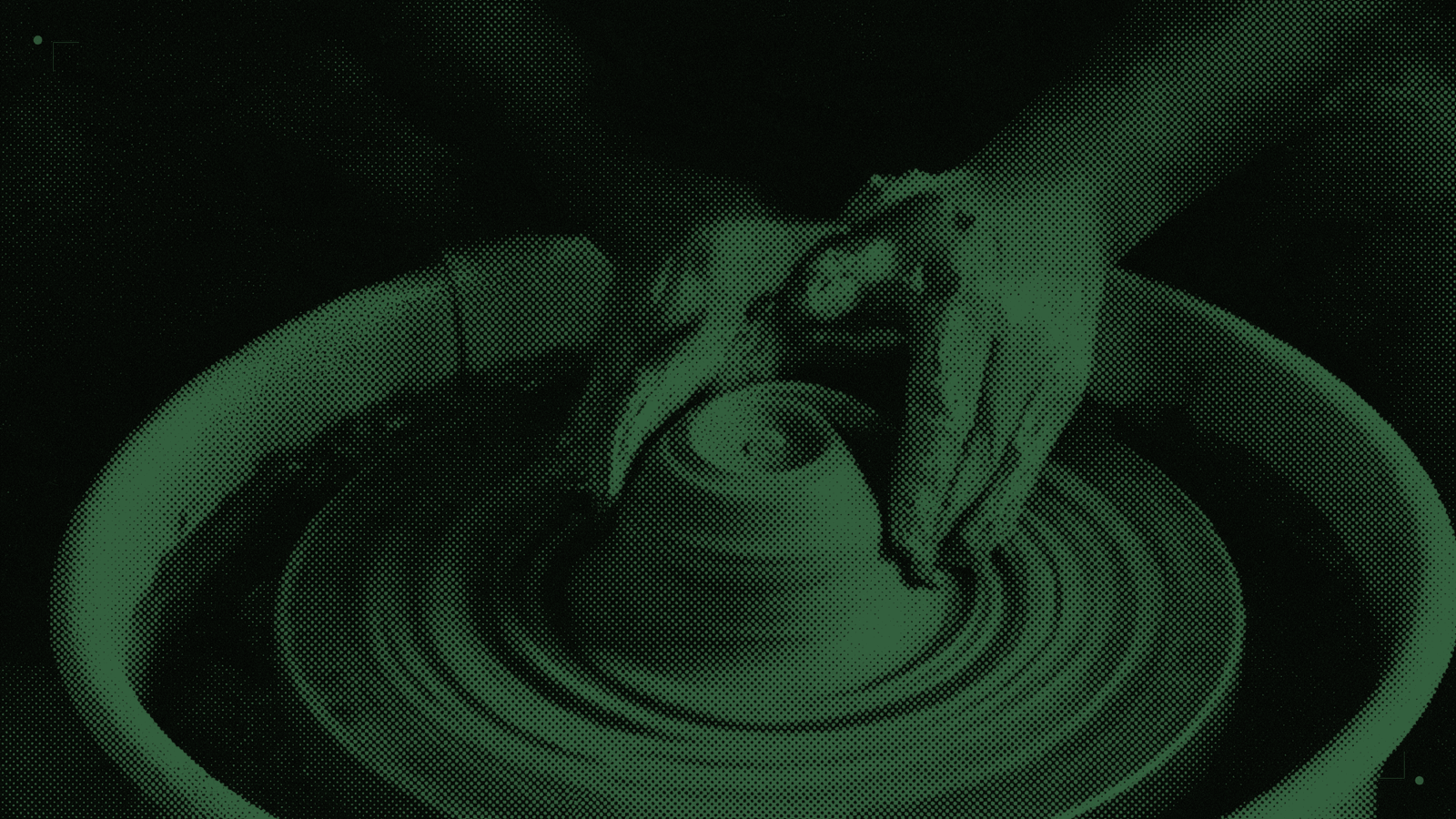 Two hands centring a lump of wet clay on a spinning potter's wheel, seen from above